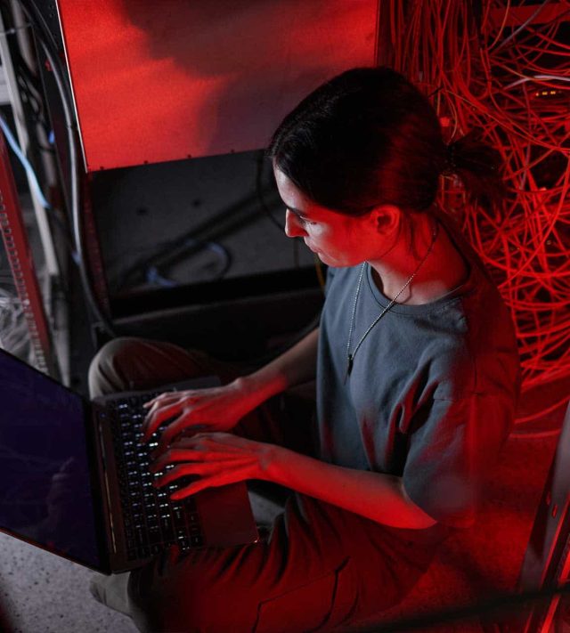 young-woman-managing-server-network-in-red-light-MG9JMVK.jpg